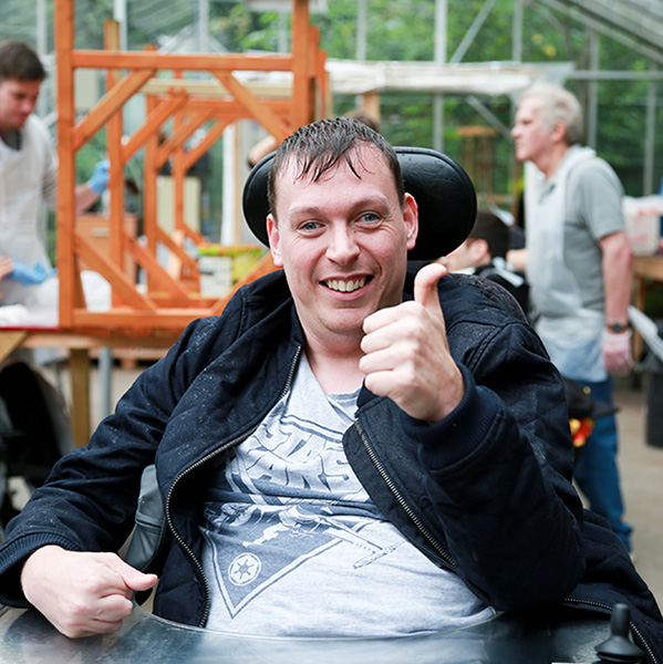 Member smiling with thumbs up in workshop