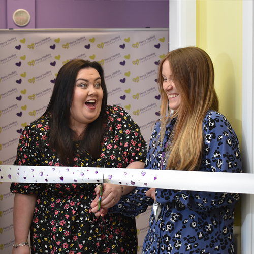 Two people smiling and cutting ribbon for the opening of the Amber Giles Innowalk